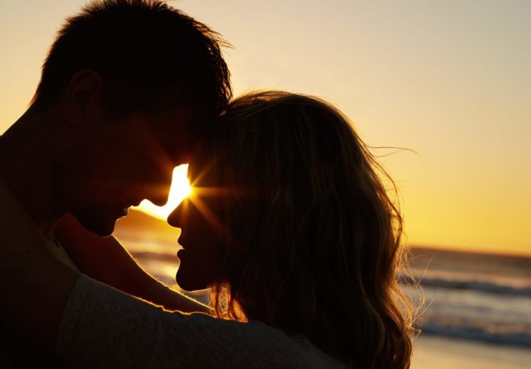 Homme et femme tête contre tête au coucher de soleil