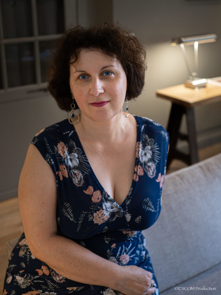 Claire assise en robe bleue avec des fleurs